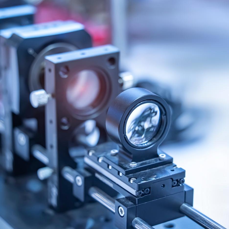 Nahaufnahme eines optischen Geräts auf einer Montageplatte mit mechanischen Halterungen und präzisen Komponenten.