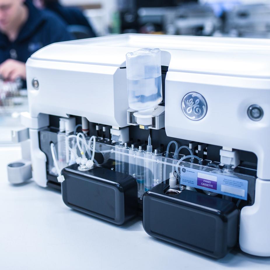 Nahaufnahme eines medizinischen Ger&auml;ts mit transparenten Schl&auml;uchen, Flaschen und Kassette auf einem Tisch.